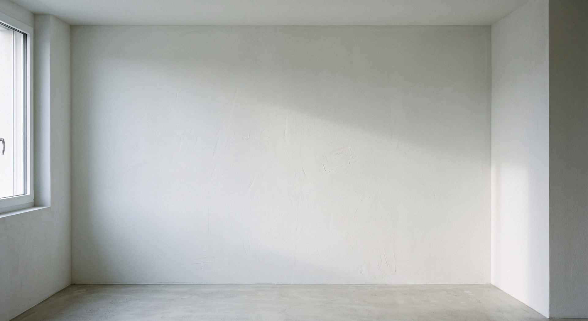 Mur intérieur fraîchement plâtré, surface blanche lisse éclairée par la lumière du jour
